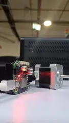 NEMA17 Closed Loop CAN Adapter Board powered on beside a NEMA 17 stepper motor